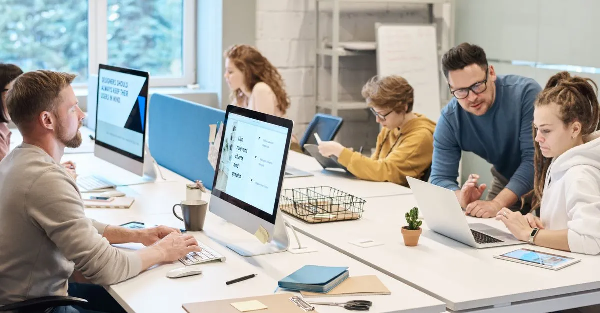 A small business team working together at computers in a modern office